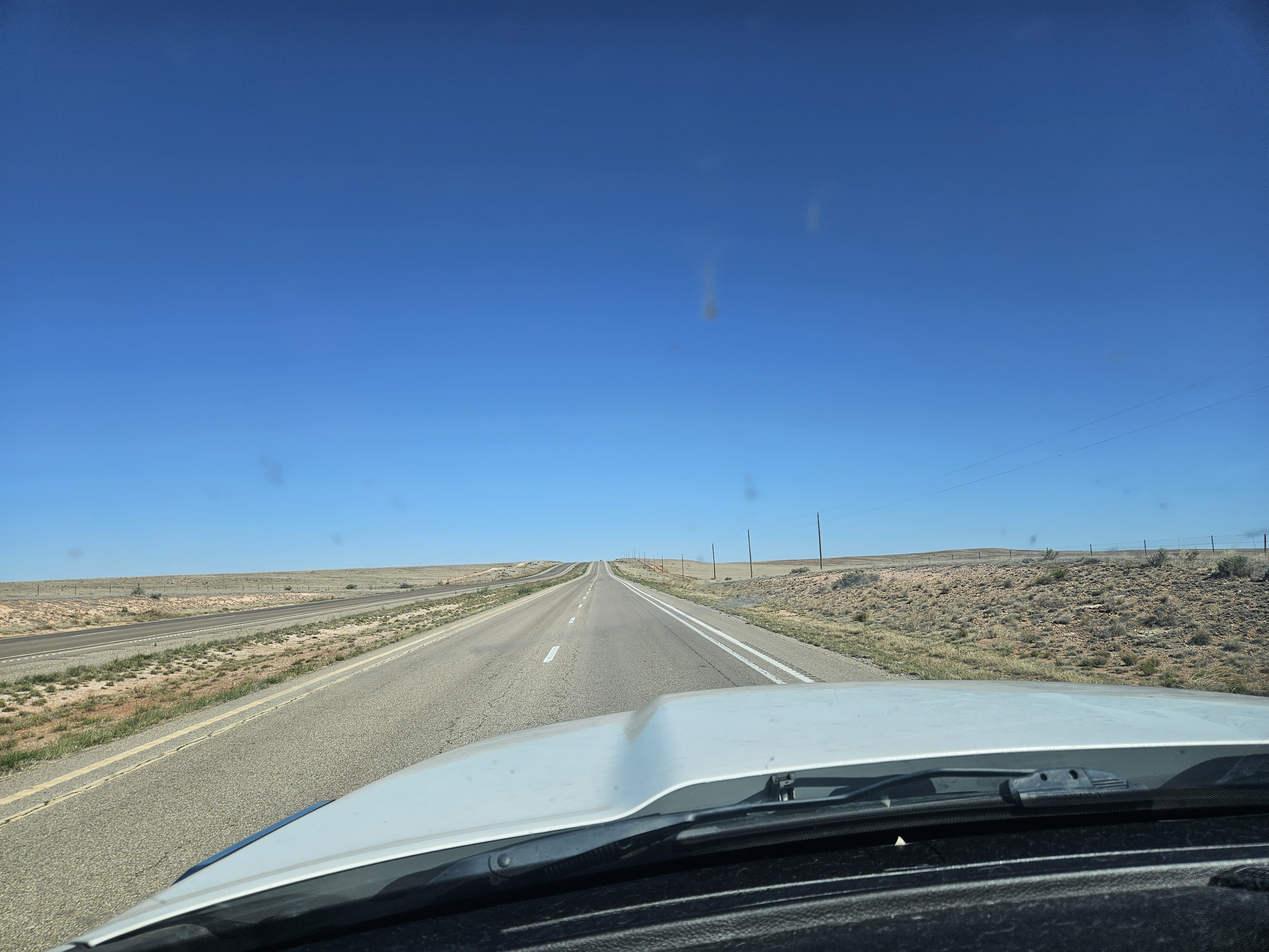 A long open road through De Baca County, New Mexico.