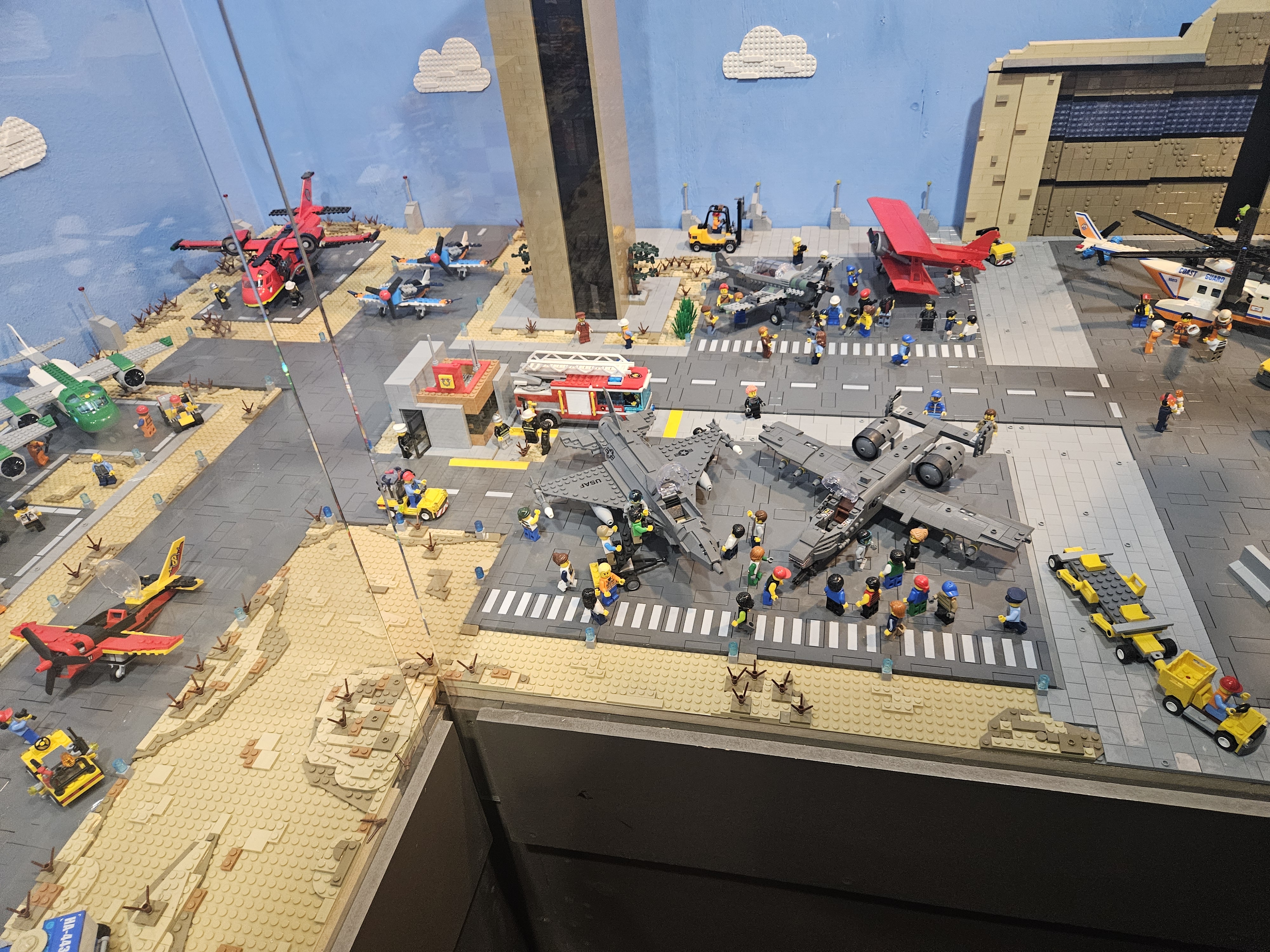 A detailed LEGO-style airport scene with planes, buildings, and minifigures.